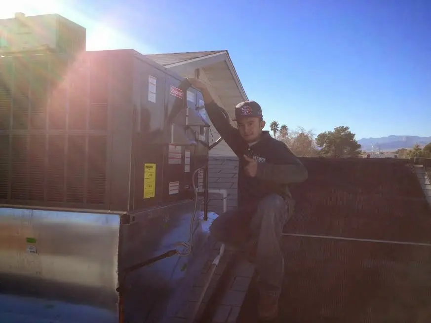 HVAC technician performing AC Tune-Up on a rooftop unit in Black Jack